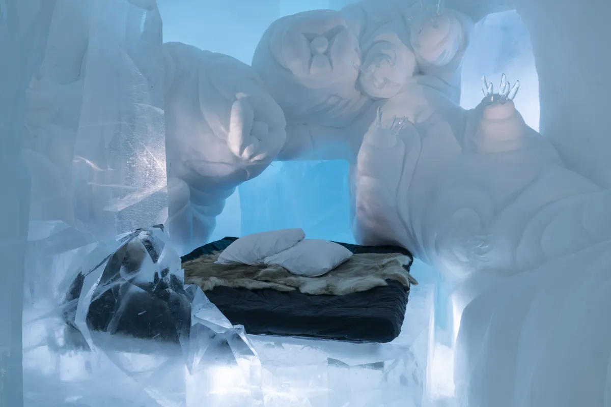 Interior of a vault cut from packed snow, lit blue along its ribs