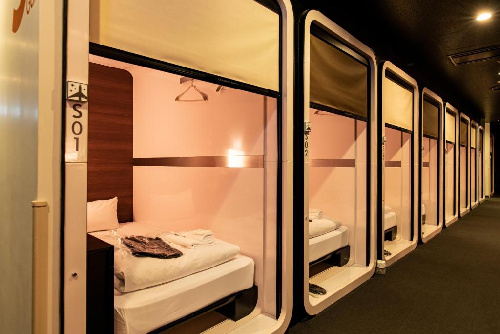 Row of screened sleeping berths along a lit corridor with pale timber fronts
