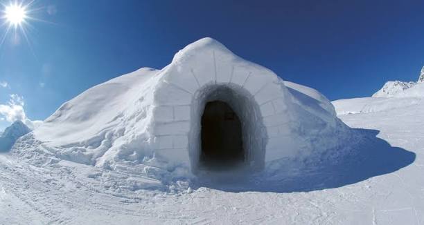 Cluster of packed snow domes on a high open mountain shelf